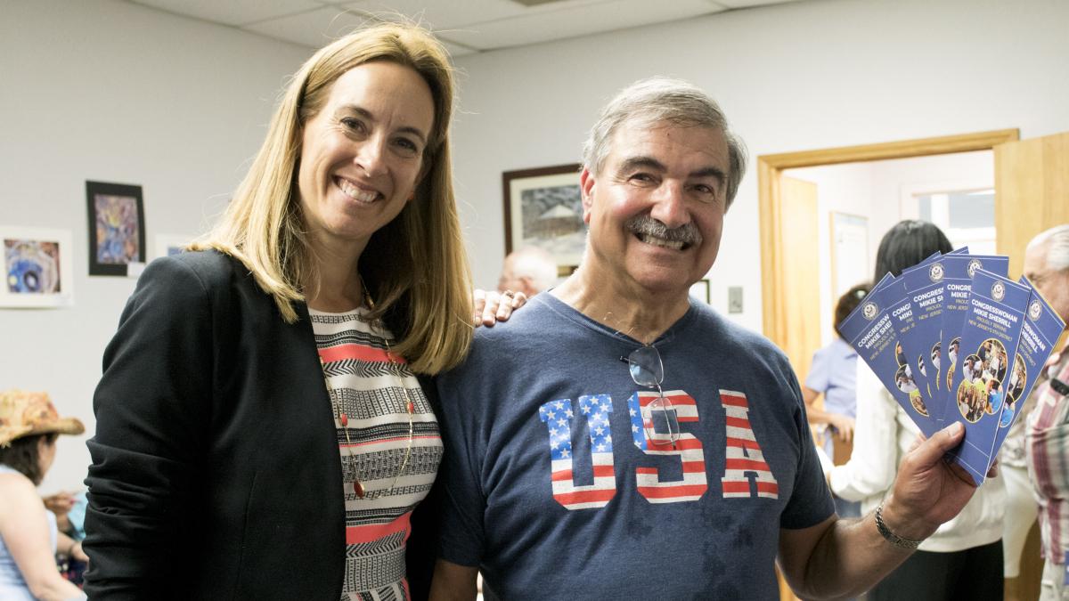 Congresswoman Mikie Sherrill standing with man with tickets in hand